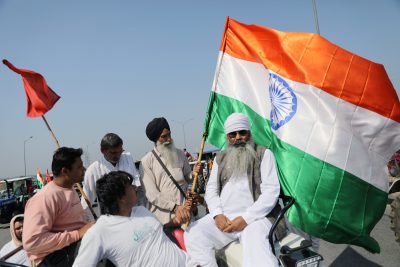 Farmers, of which one holds an India's flag, block an expressway to mark the 100th day of the protest against the farm laws, near Kundli border, in Haryana, India 6 March 2021. (Photo: Reuters/Anushree Fadnavis).