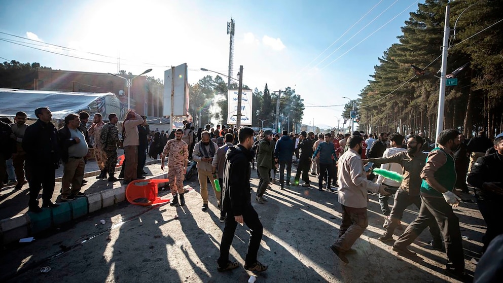 People stay next to an injured man after an explosion in Kerman, Iran, Wednesday, Jan. 3, 2024. Explosions at an event honoring a prominent Iranian general slain in a U.S. airstrike in 2020 have killed at least 73 people and wounded over 170 others, state-run media in Iran reported Wednesday. (AP Photo/Mahdi Karbakhsh Ravari)