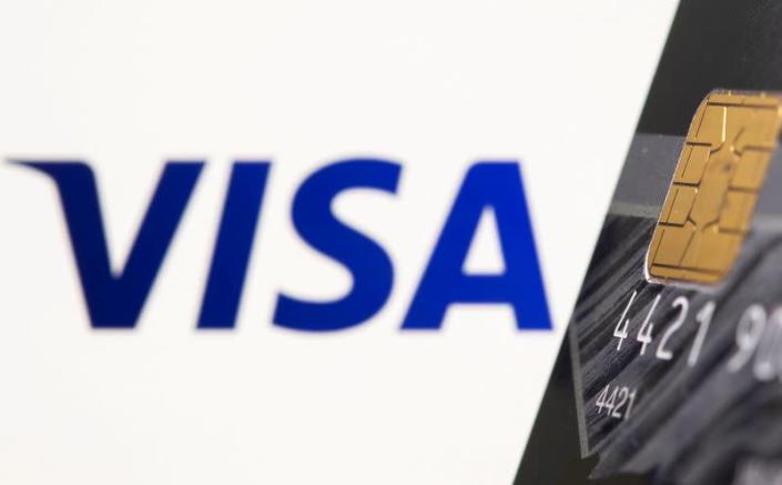 FILE PHOTO: Credit card is seen in front of displayed Visa logo in this illustration